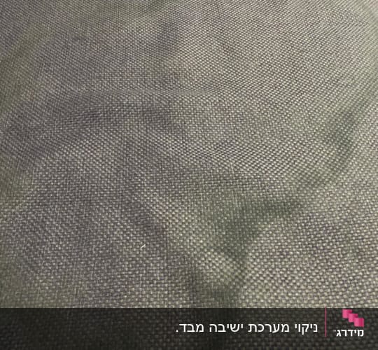 תקריב של כתם מים או נוזל על ספת בד לפני ניקוי